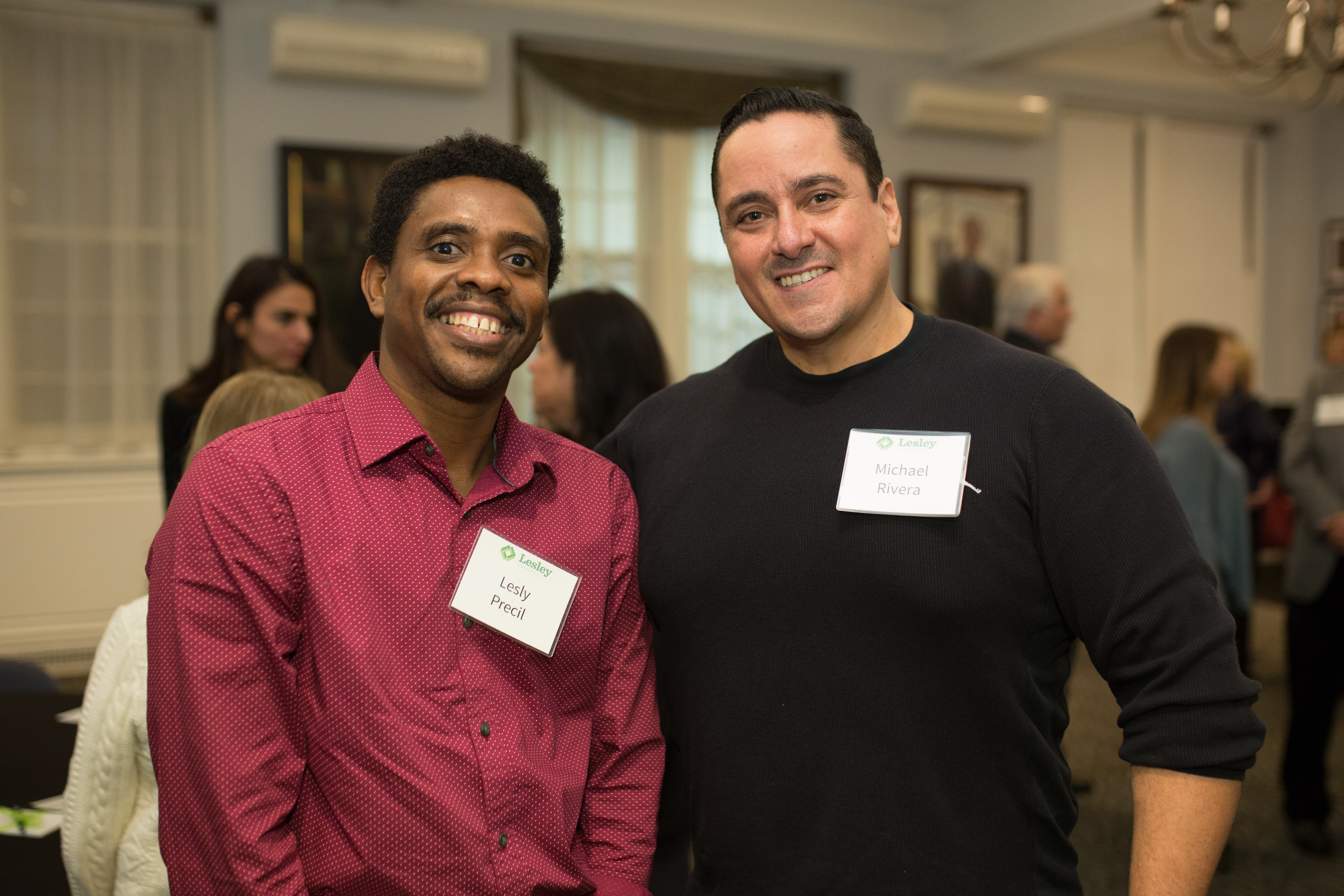 Lesly Precil in a red shirt and Michael Rivera in a black shirt pose and smile together.