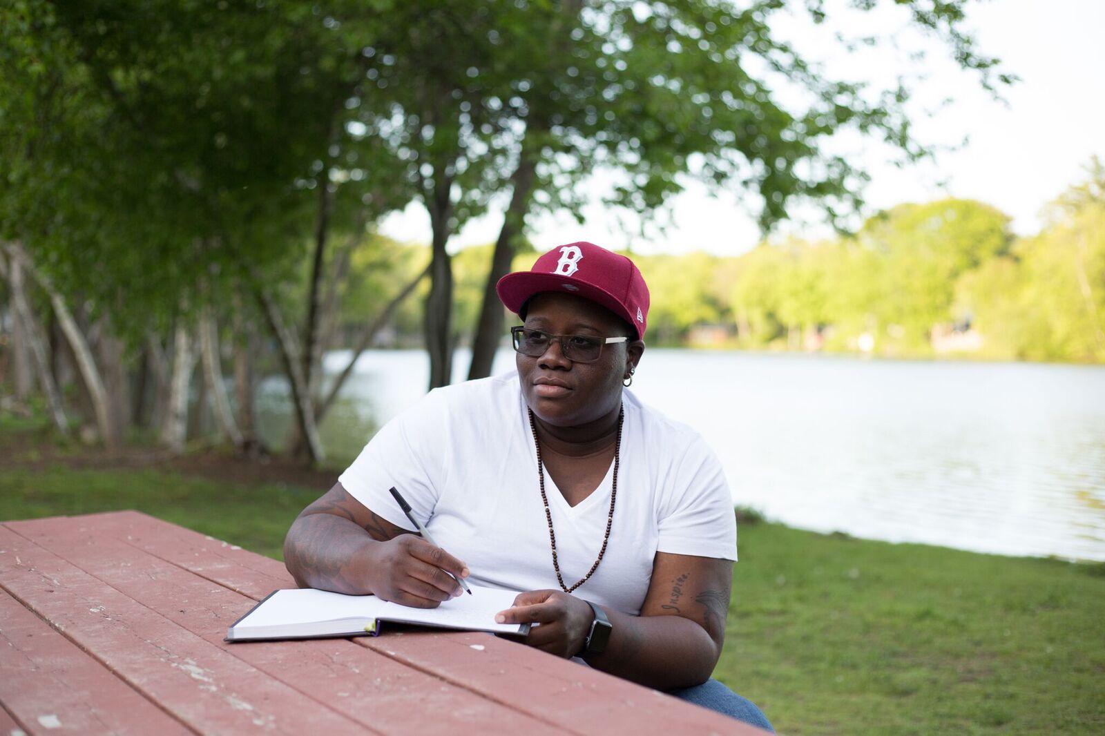 Aqueela Culbreath-Britt sitting outside and writing