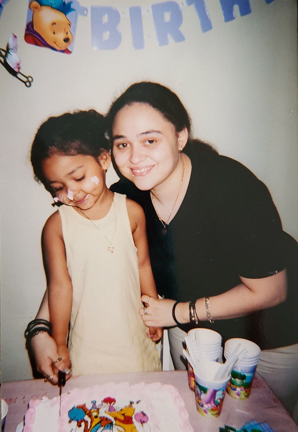 Photo of Dejah and Carolina at Dejah's childhood birthday party with frosting on her nose.