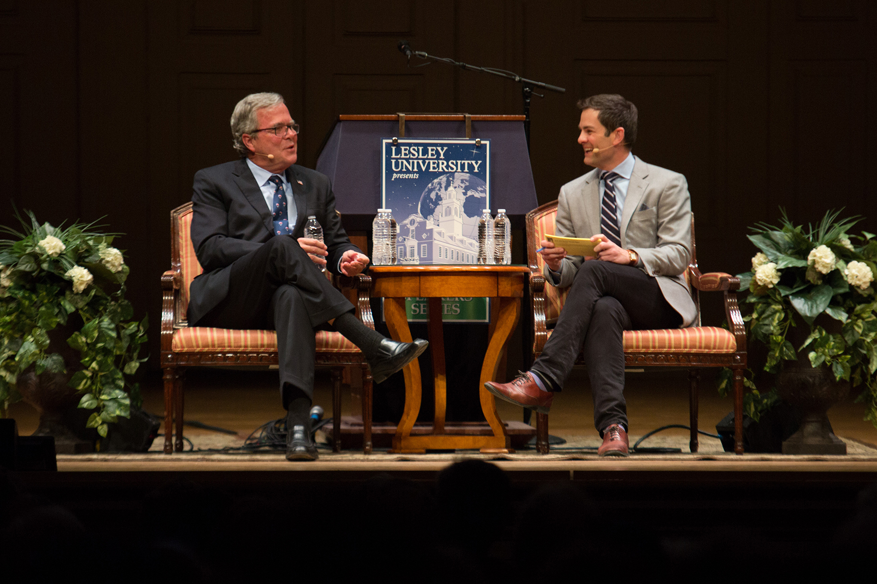 Jeb Bush and Jared Bowen are seated, conversing on the Symphony Hall Stage