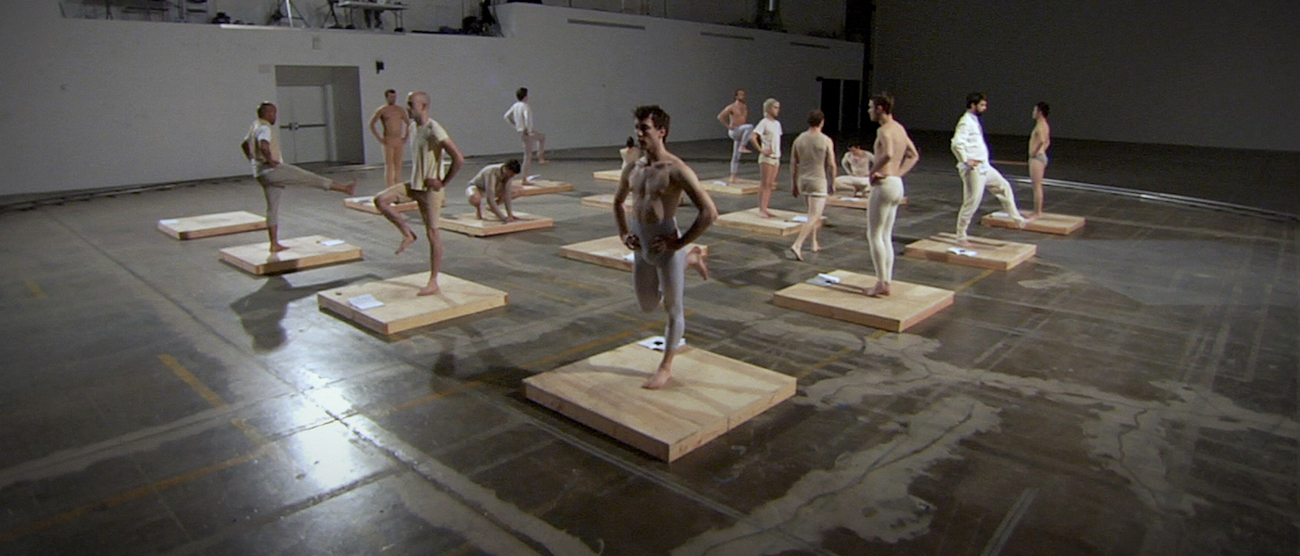 Photo of men standing in different poses on wooden platforms