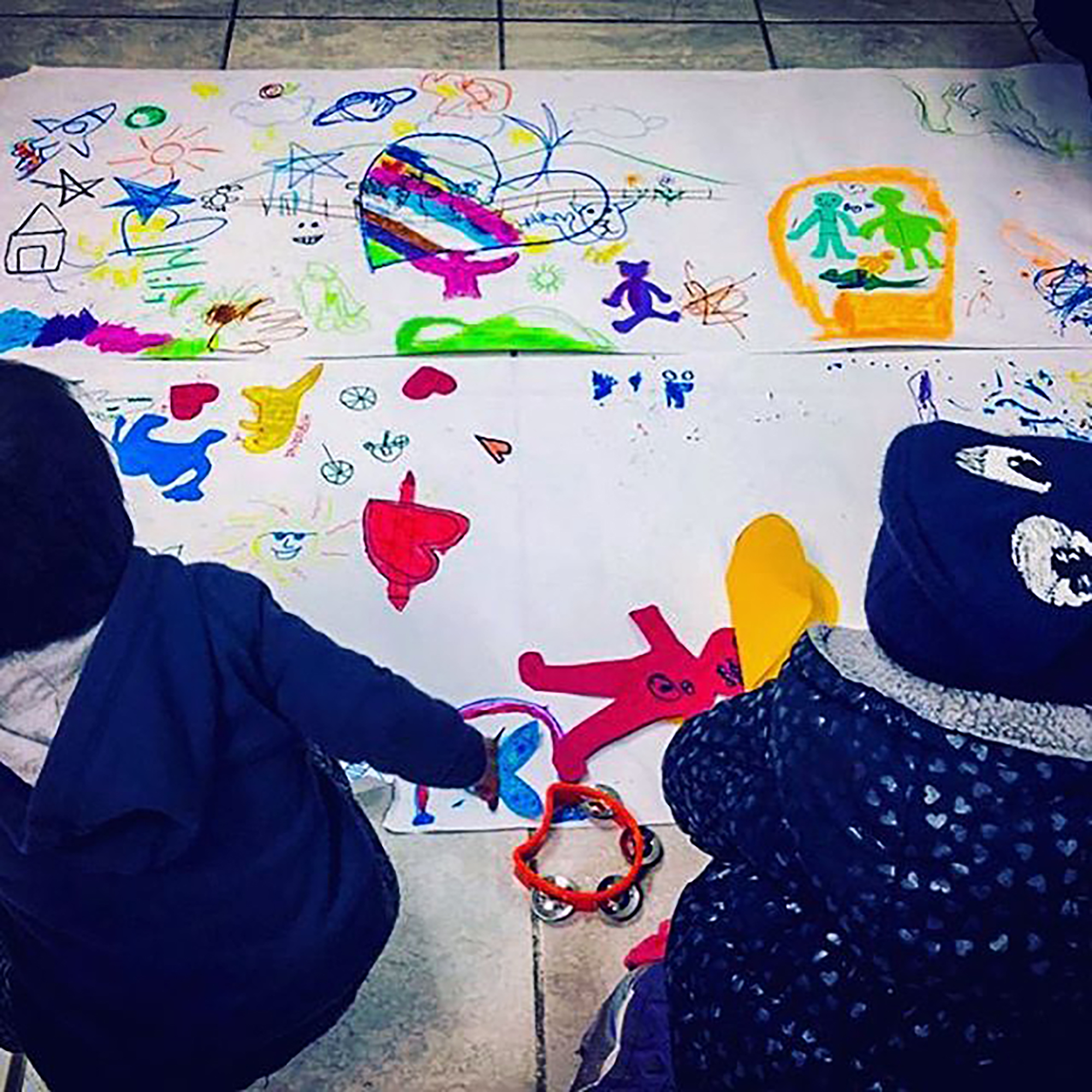 Kids looking at a large paper full of coloring