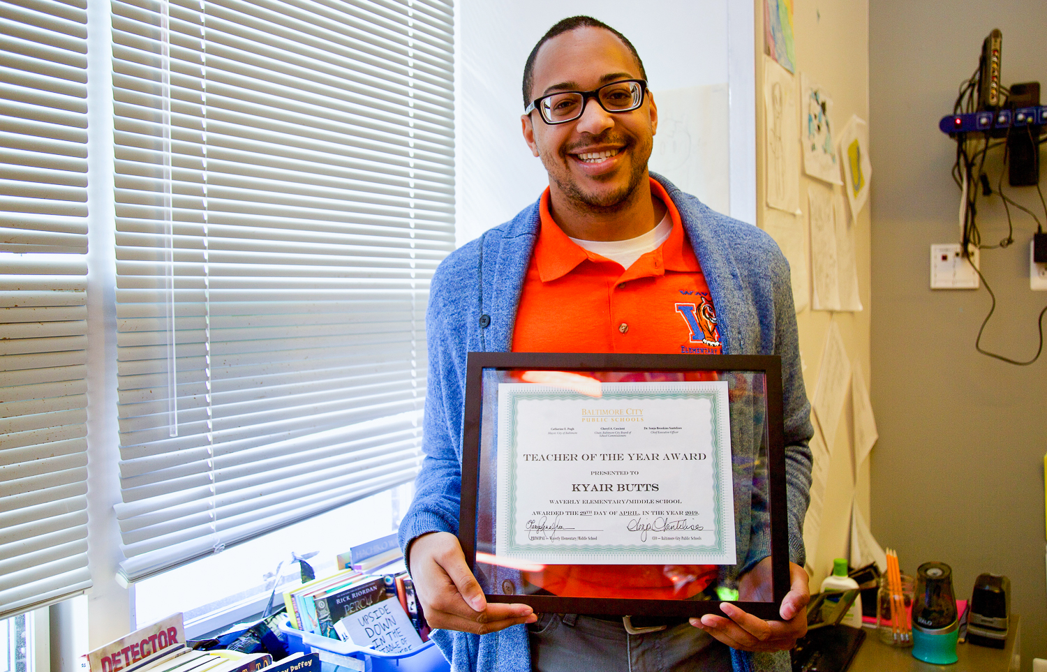 Kyair Butts holding his framed award.