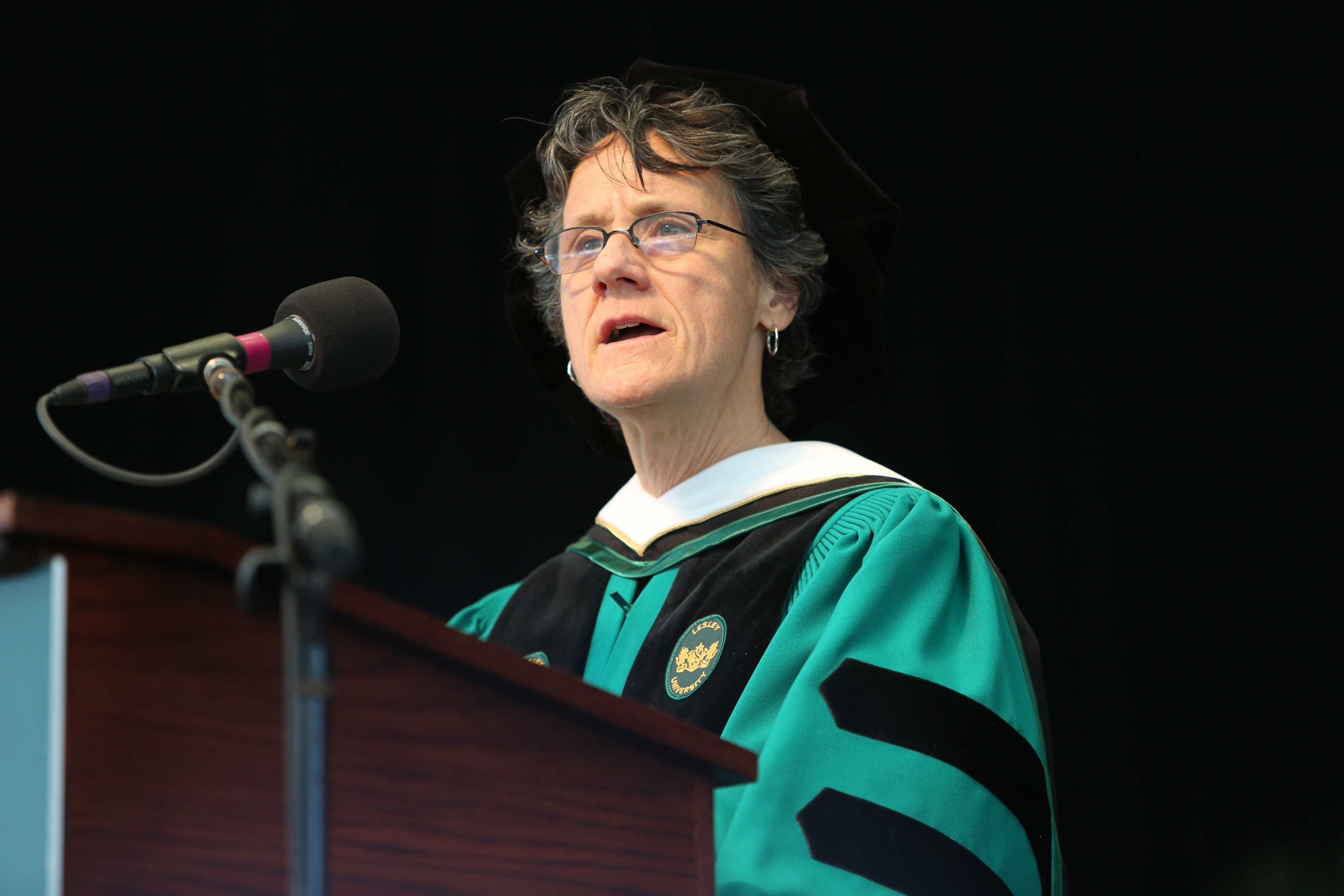 Molly Baldwin in cap and gown speaking at podium