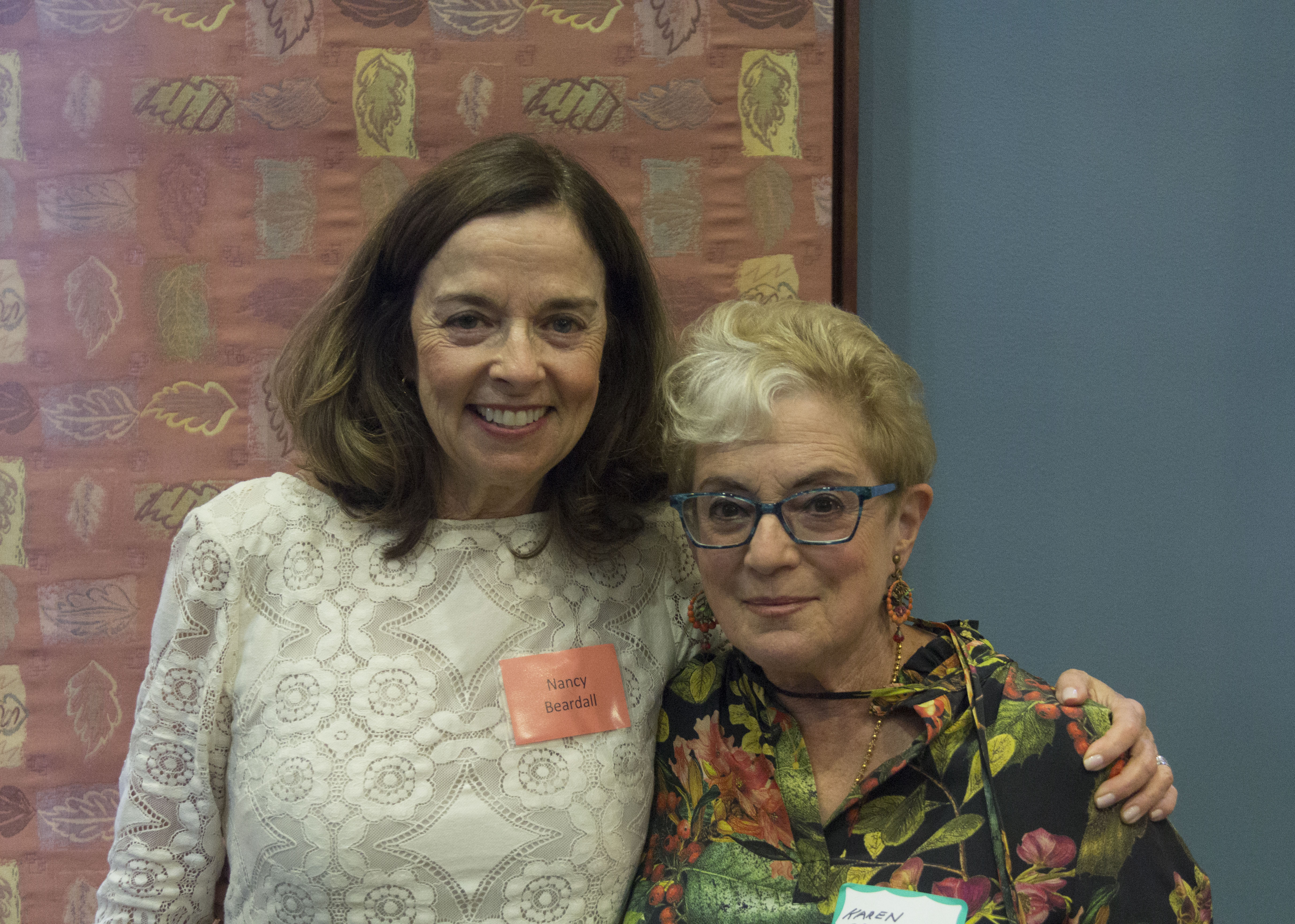 Two women smiling with their arms around each other, posing for a photo