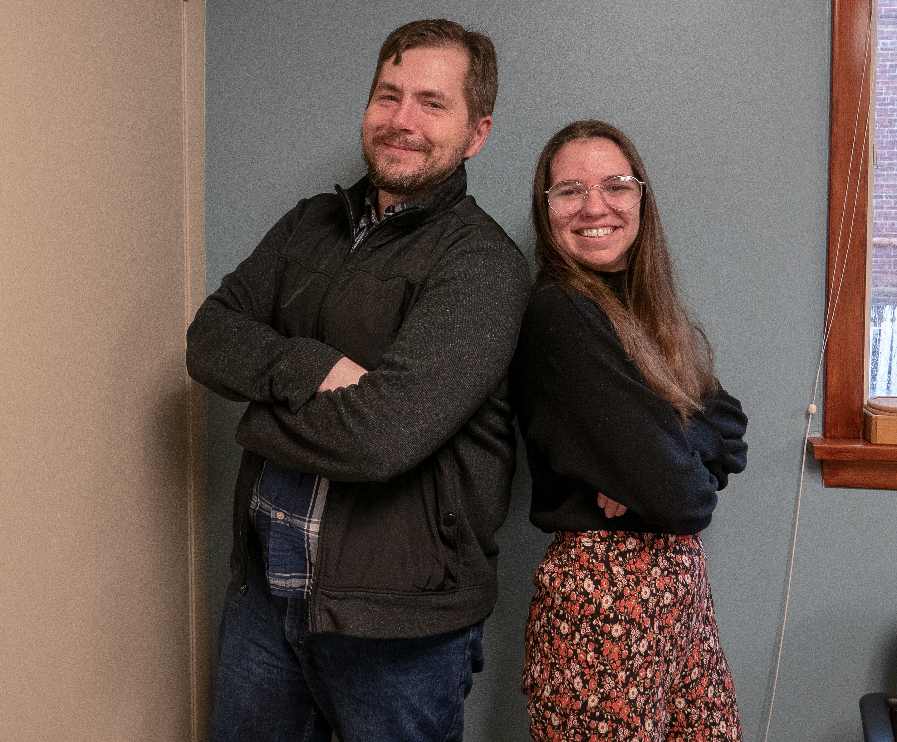 Chris Clark and Nicole Mello stand back to back smiling