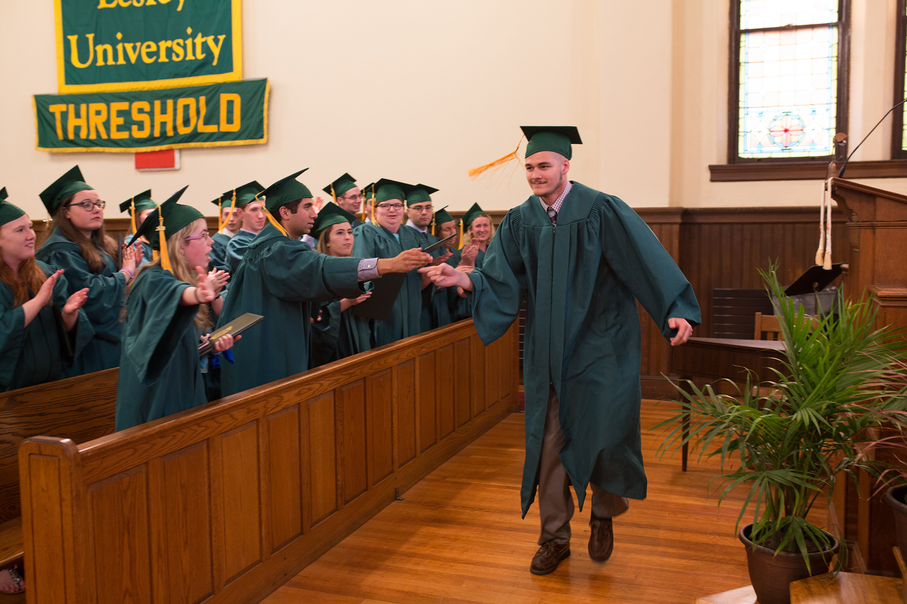 Graduate Chris Satterfield receives a high five as he approaches the stage.