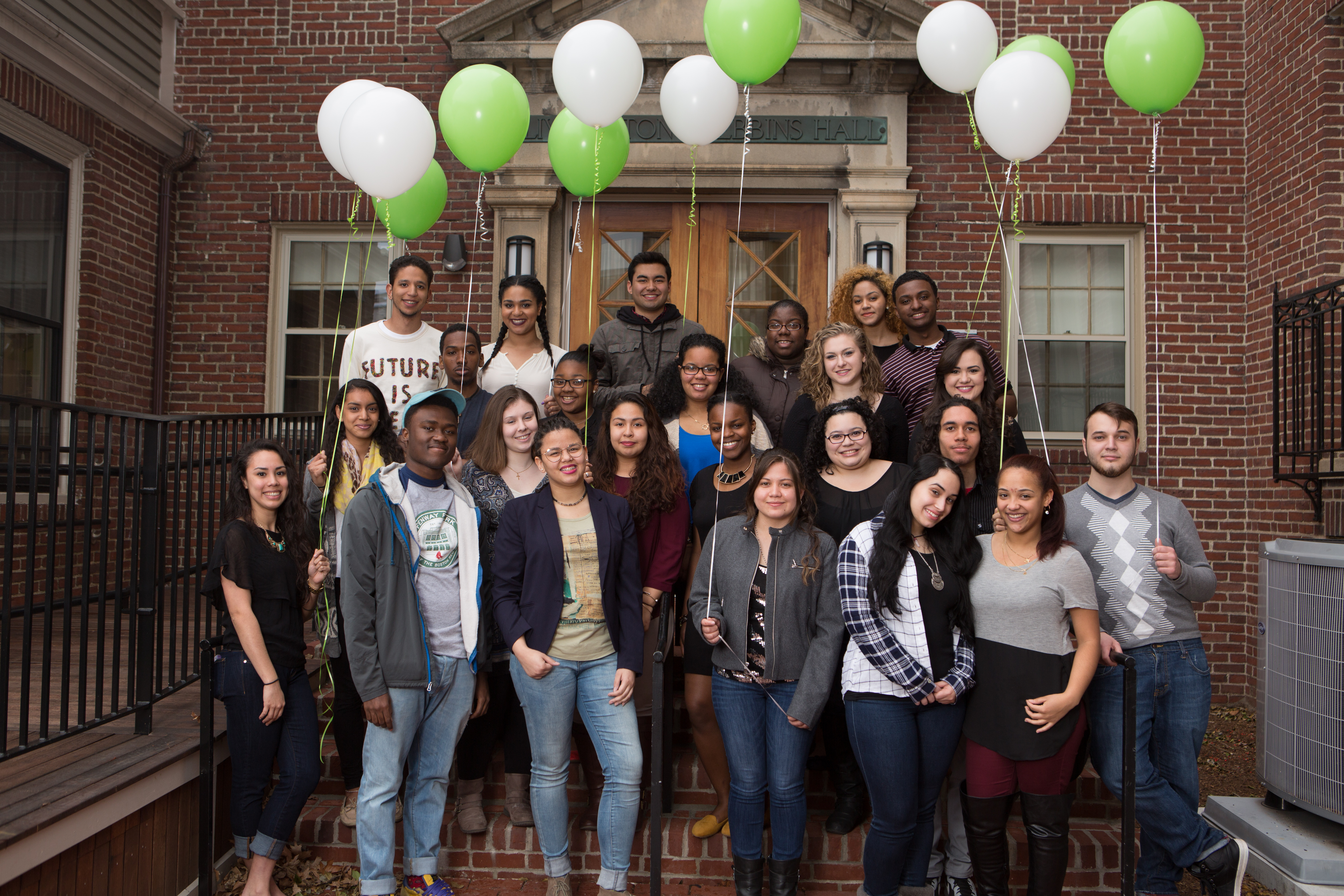 The USI students as freshmen standing outside Alumni Hall with green and white balloons.