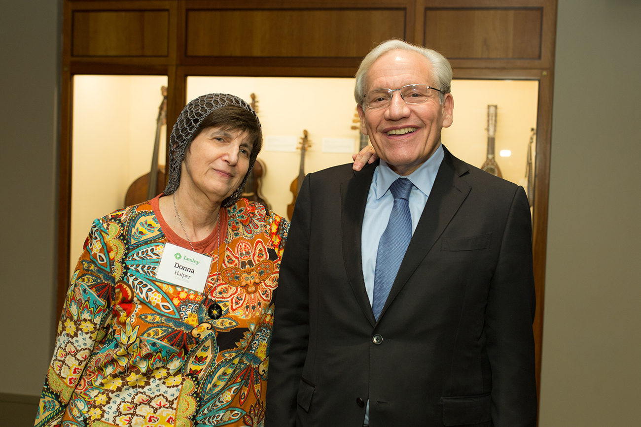 Man and a woman posing for a photo and smiling in front of a case of instruments.