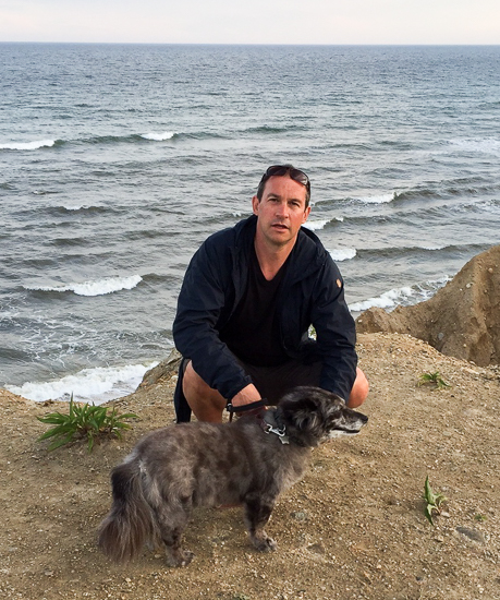 Scott Loring Sanders photographed on the beach with his dog.