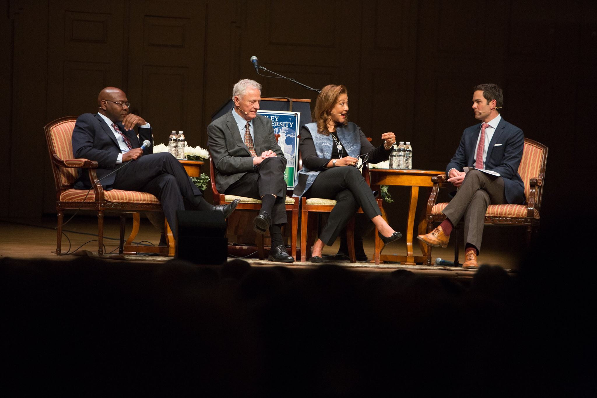 The panelists talk on stage.