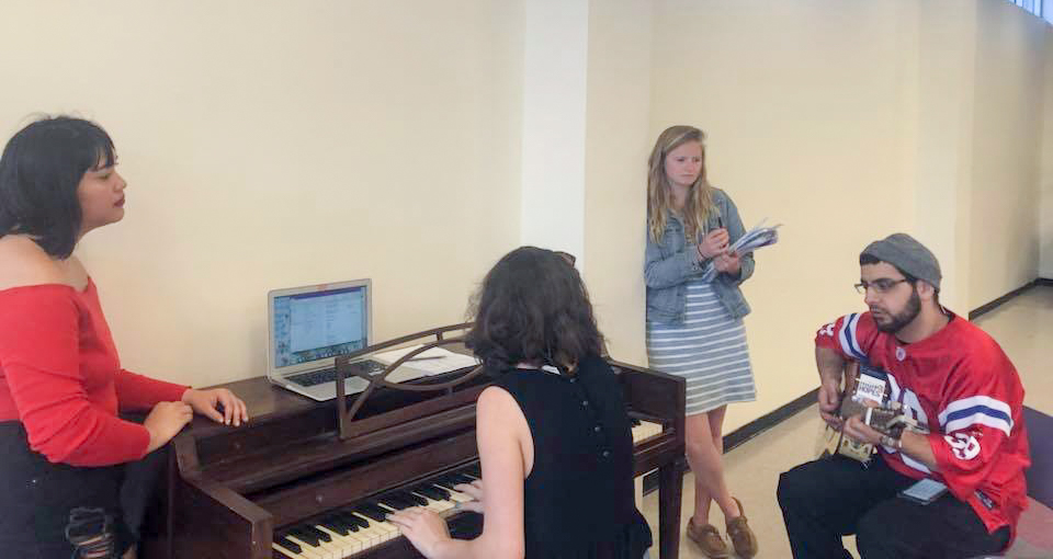 Students practice at a piano.