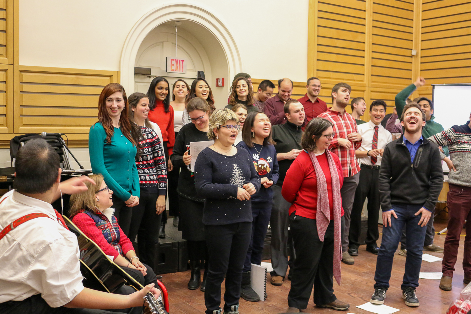 Choir wearing holiday sweaters and singing