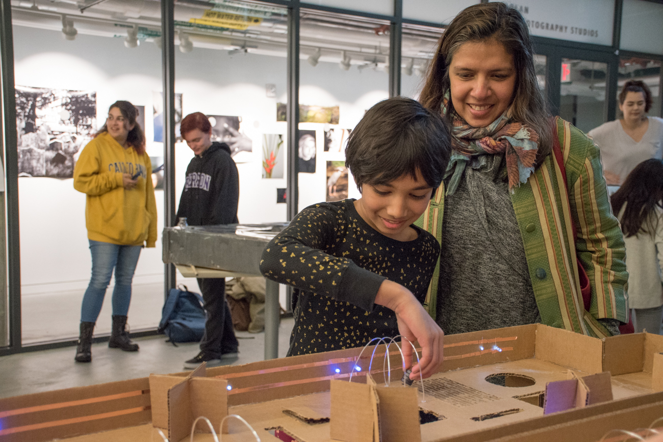 A mother and daughter smile while playing a game.