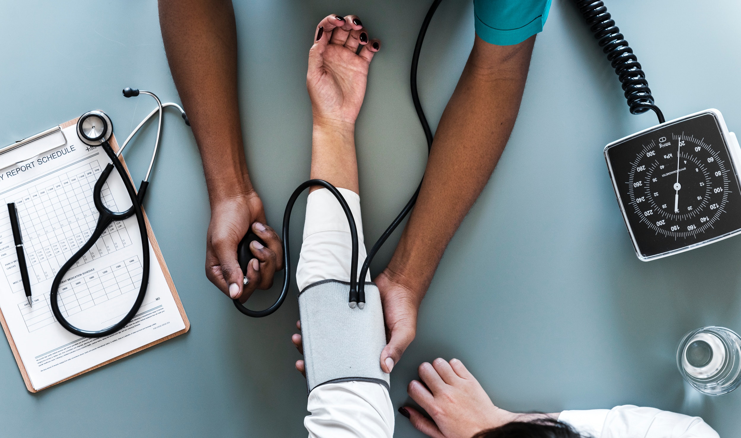 Overhead view of a person's arm and someone taking their blood pressure.