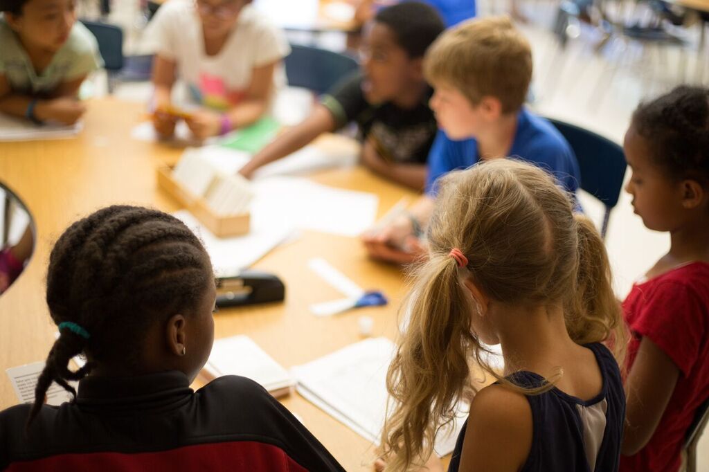 classroom of elementary students sitting around a table