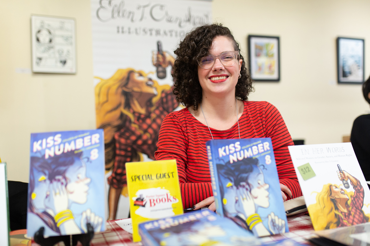 Ellen Crenshaw sits at a table with her books on it at an Expo