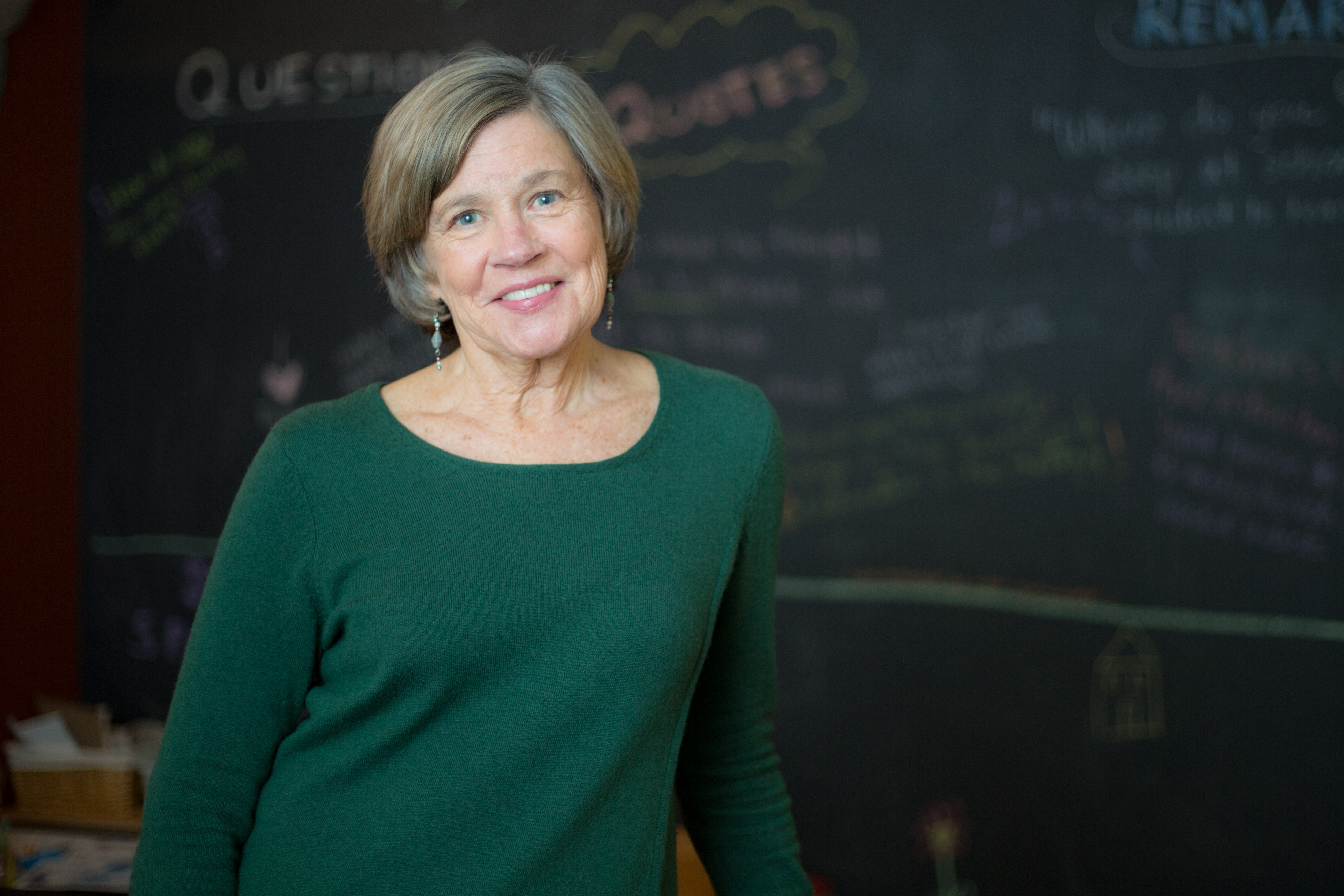 Nancy Carlsson-Paige standing in front of chalkboard smiling