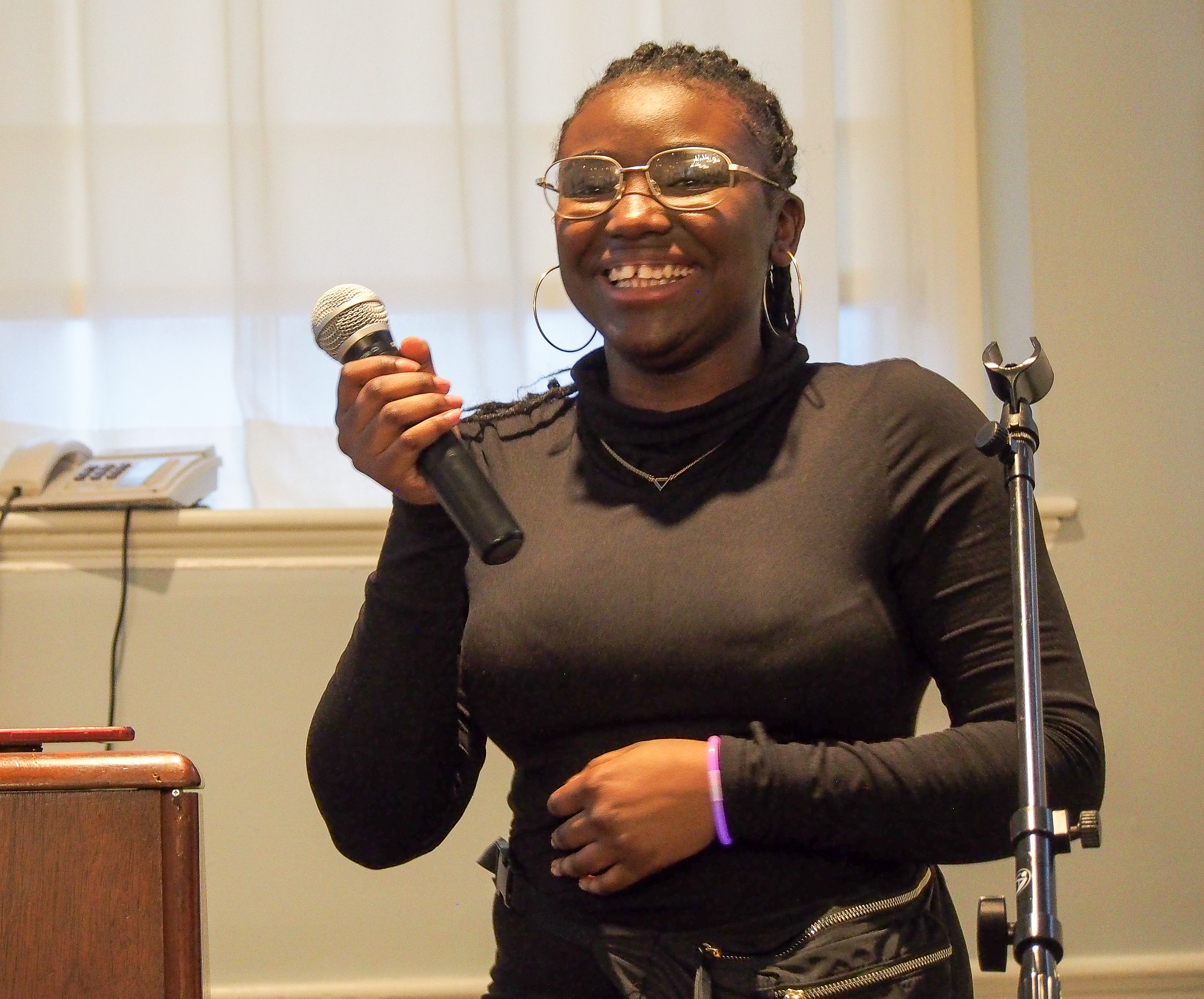 Photo of Nirmala Legale holding a mic and smiling