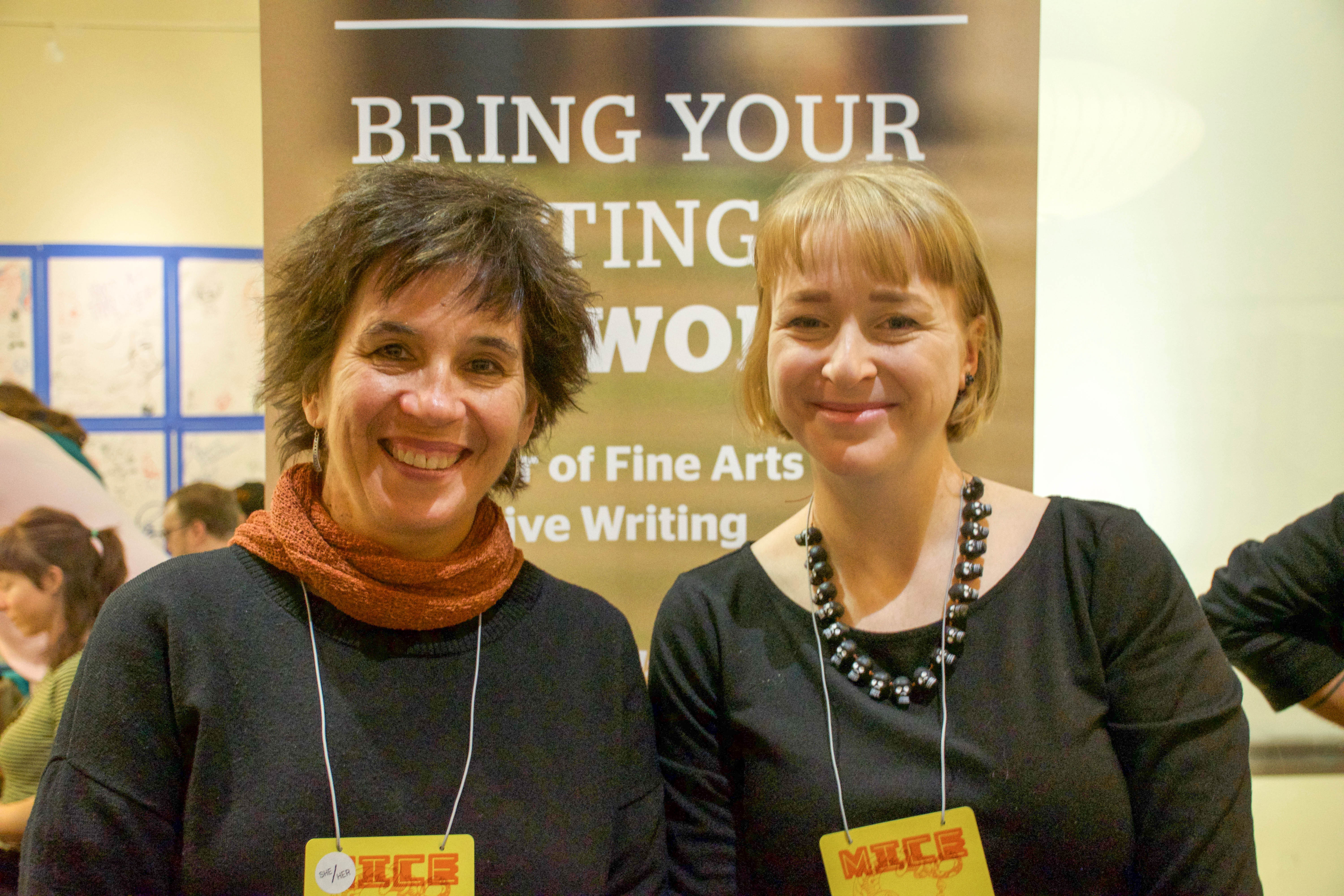 Two women at an information table at a comic book expo