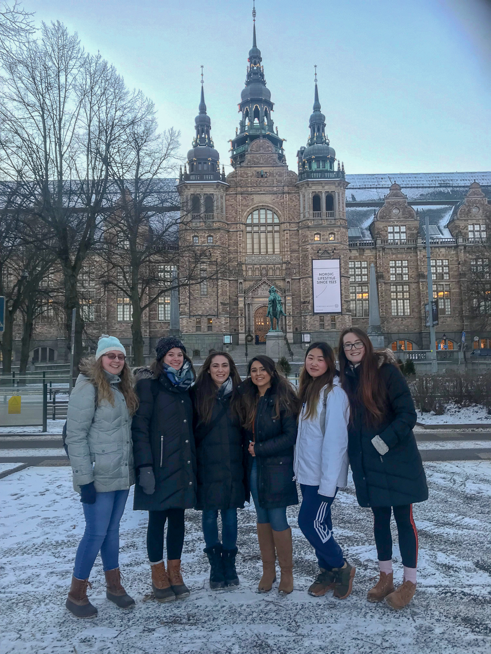 Students stand in front of a building in...?