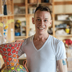 Arthur Halvorsen holding a large, colorful vase in a studio