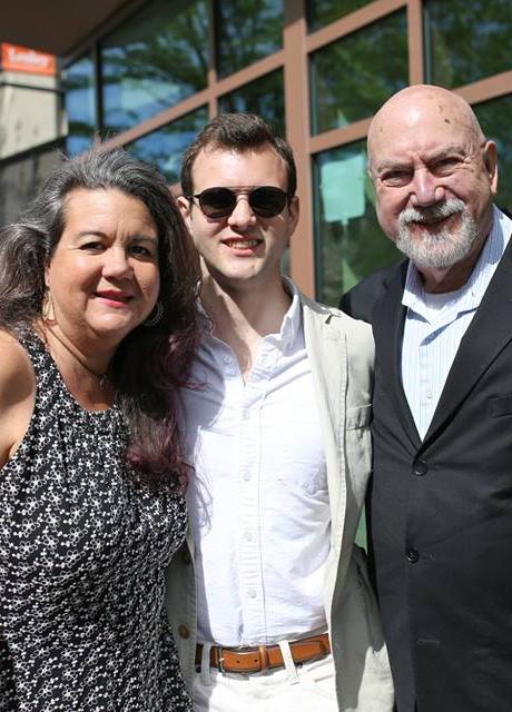 Recent Graduate and Parents Smiling at the Camera