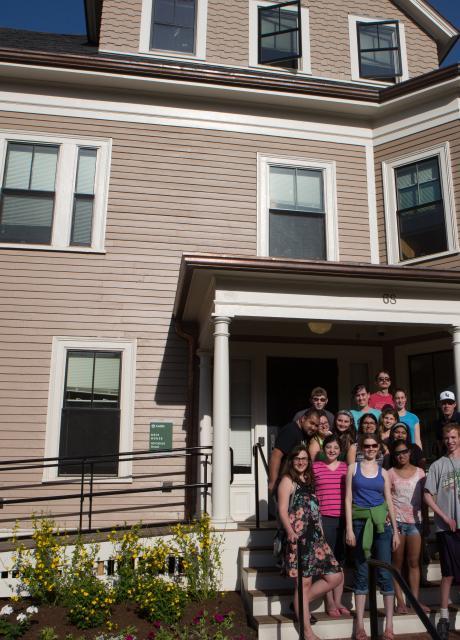 victorian house with threshold students out front 