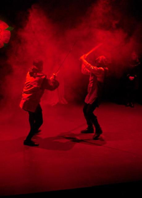 two actors sword fighting on a stage