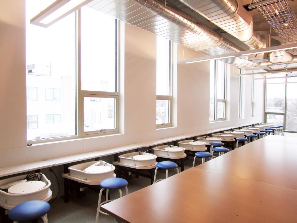 empty ceramic studio with potter's wheel stations along the windows