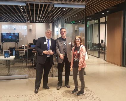 student Jess Brown stands with two judges at the Microsoft Education Center Office