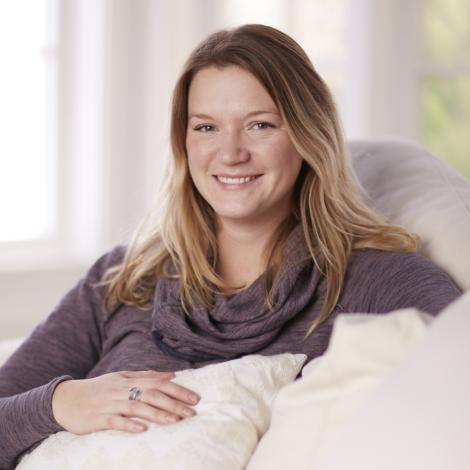 Photo of Camilla sitting on a white couch