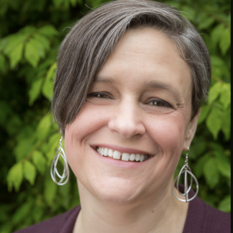 Color photograph from the neck up of Cynthia Platt smiling at the camera. 