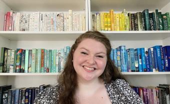 alumna annalise errico smiling in front of a bookcase