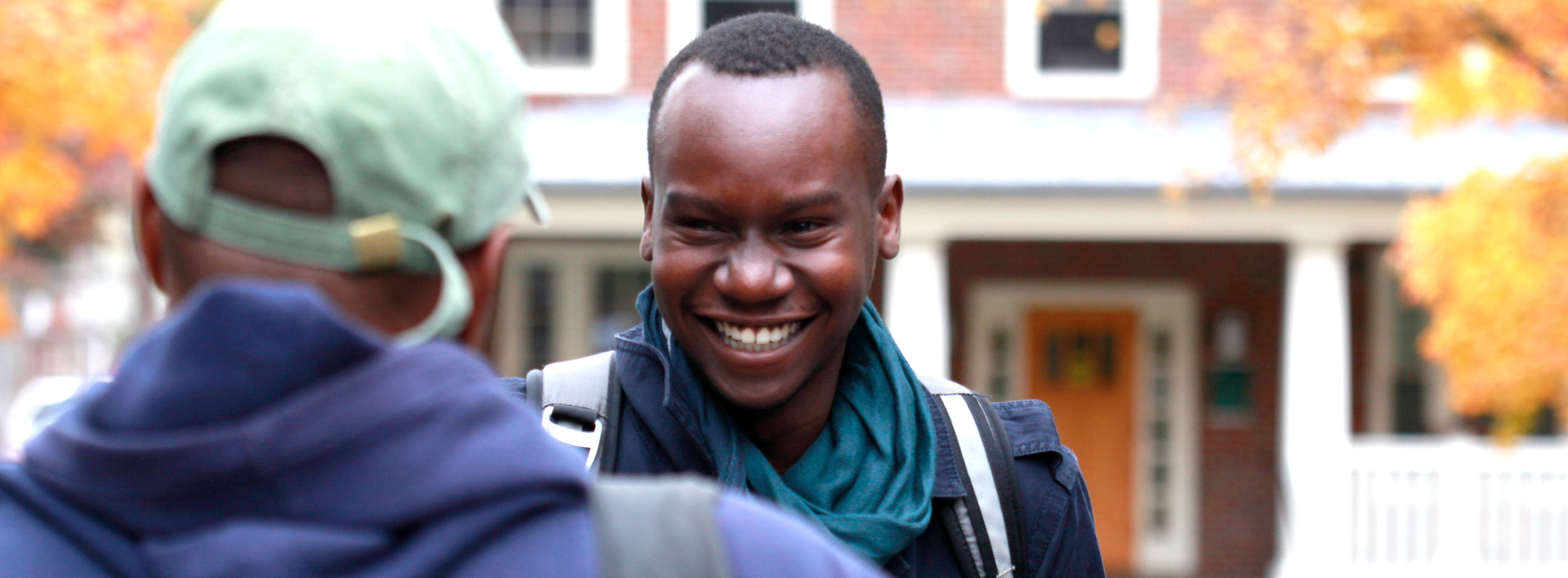 Two students talking outdoors on fall day BIPOC