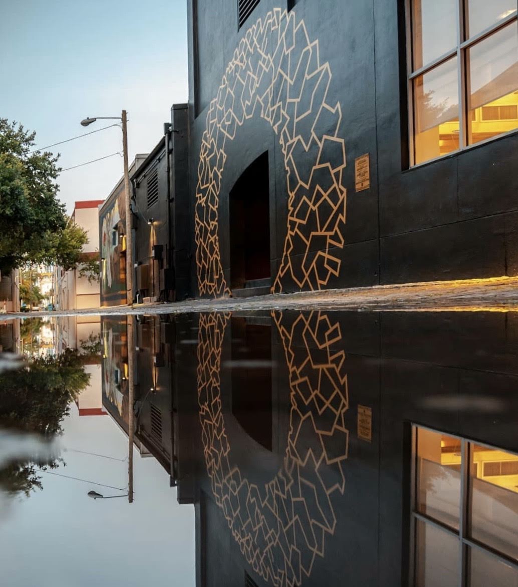 Outdoor mural painted in gold with a black background